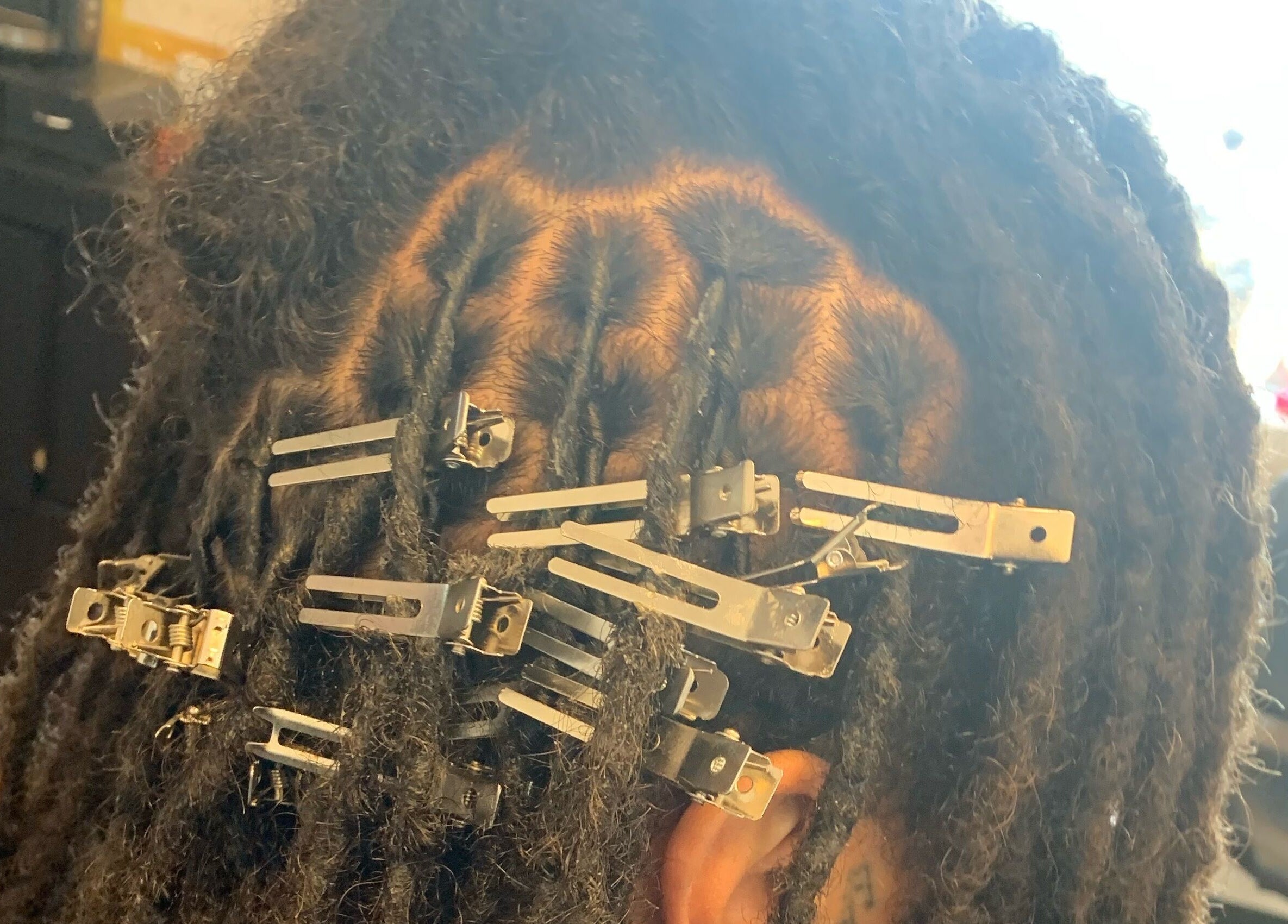 Intricate dreadlock styling with clips at The Root Refresh Salon, Minneapolis, Minnesota, US.