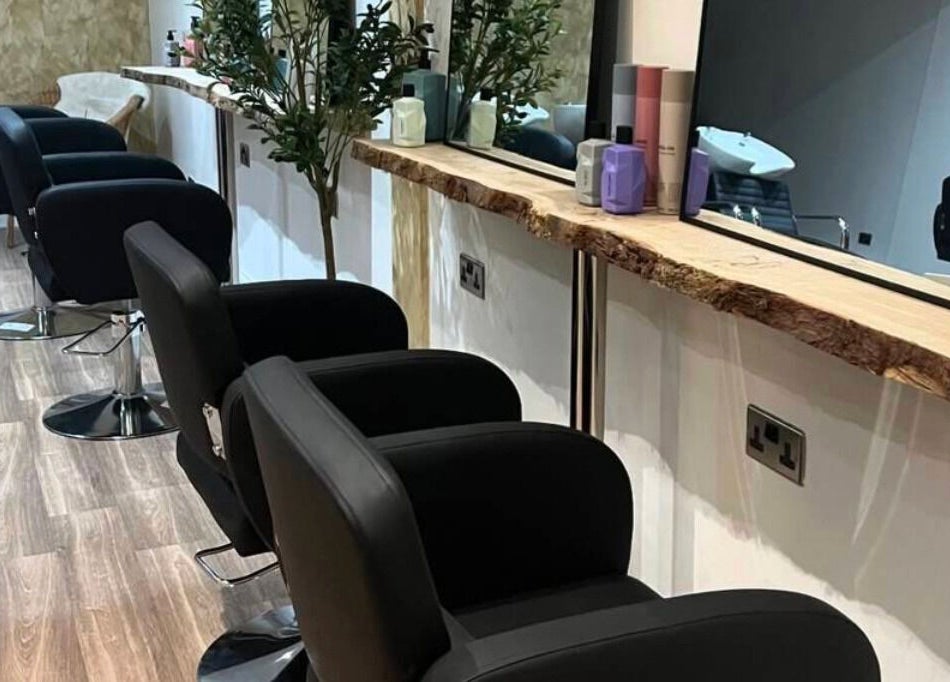 Stylish hair salon at U Aesthetics, South Elmsall, England, GB with modern black chairs and large mirrors.