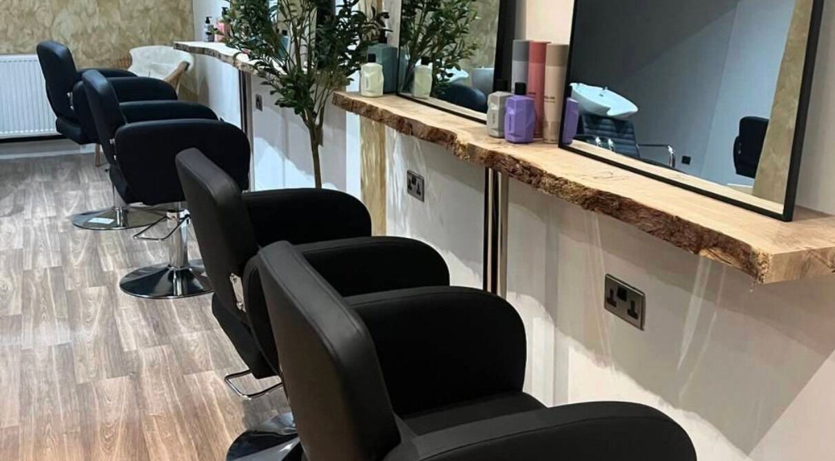 Stylish hair salon at U Aesthetics, South Elmsall, England, GB with modern black chairs and large mirrors.