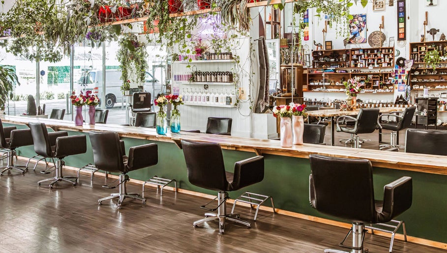 Interior of Chameleon New Age Salon, Surfers Paradise, Queensland, AU, featuring stylish chairs and greenery.
