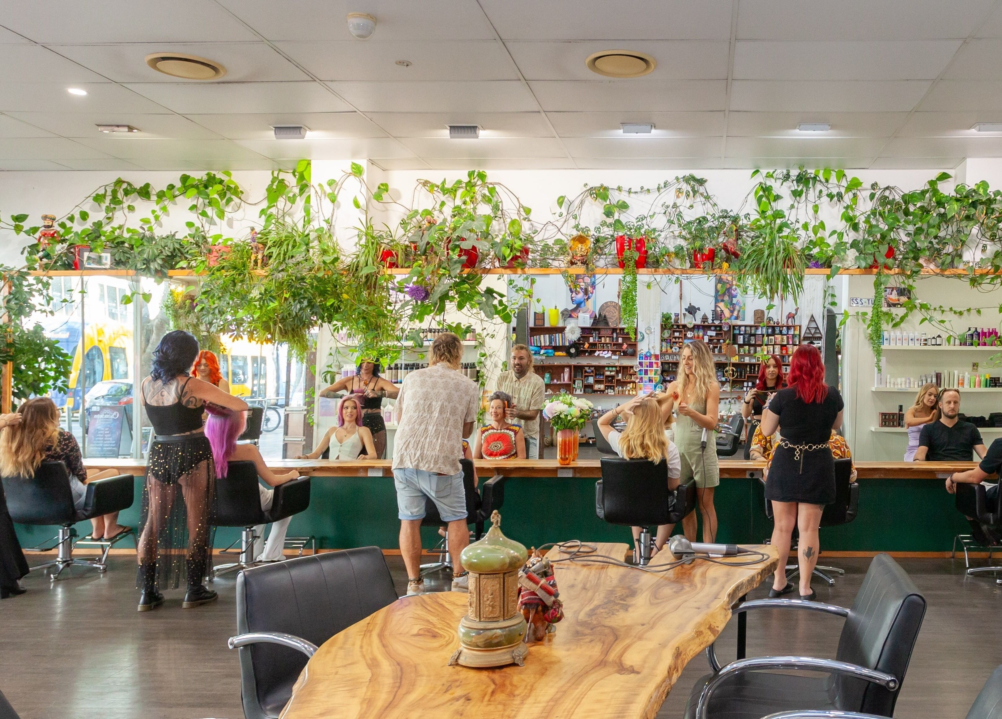 Chameleon New Age Salon in Surfers Paradise, Queensland, AU, bustling with clients and stylists under lush greenery.