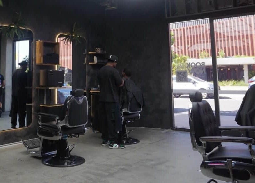 Interior of First Rule Barber in Sippy Downs, Queensland, AU showing barber stations and clients receiving haircuts.