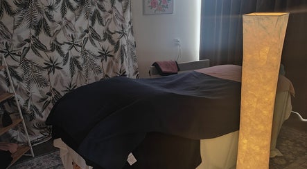 Cozy massage room at Therapeutic Bliss Massage, Milford, North Shore, NZ with serene lighting and decor.