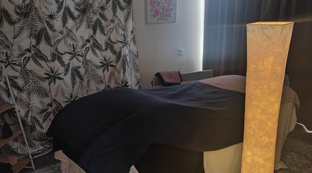 Relaxing massage room at Therapeutic Bliss Massage, Milford, North Shore, NZ, featuring soft lighting and elegant decor.