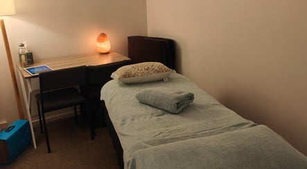 Massage room at Therapeutic Bliss Massage, Auckland, Auckland, NZ, with cozy table and warm lighting.