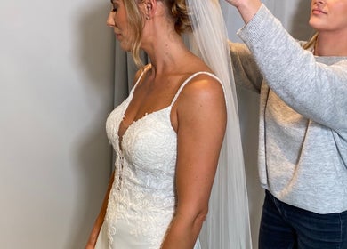 Stylist at Emma Lock Hair and Makeup in South Benfleet, England, GB, adjusts a bride's veil.