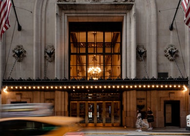 Elegant facade of Grand Central in New York, New York, US, warmly lit by chandeliers inside.