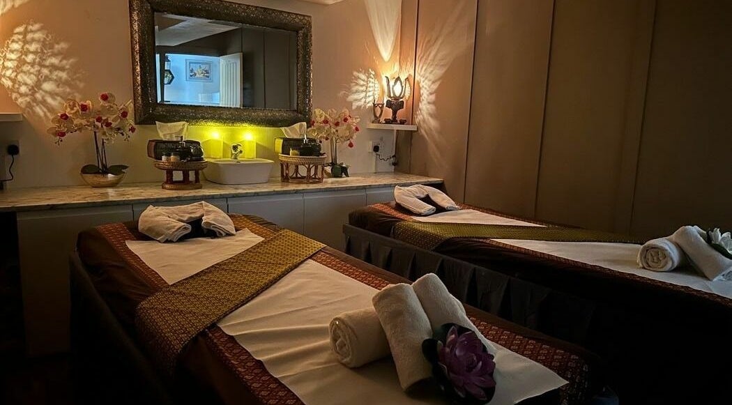 Relaxing massage room at Thai House Spa, Banbury, England, GB with two tables and ambient lighting.