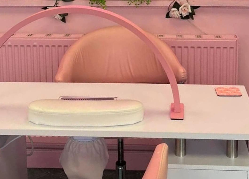 Elegant nail station at L.C Beauty and Aesthetics in Wigan, England, GB with pink decor and plush seating.