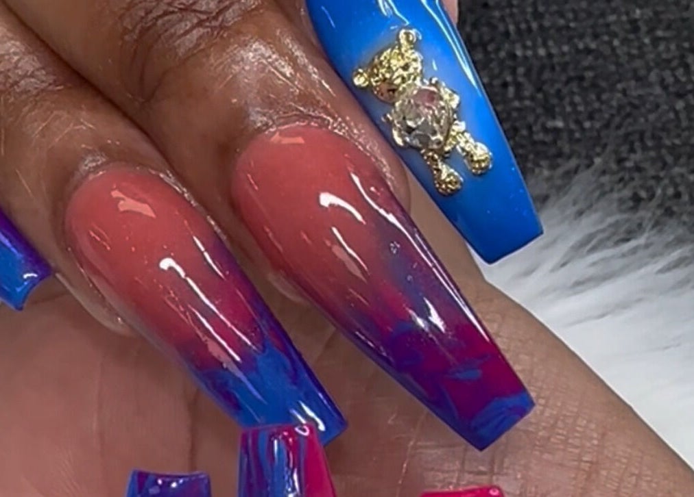 Colorful nail art with gradient design and teddy bear charm at D’yVonne’s Nails and Beauty Bar, Forest Park, Georgia, US.