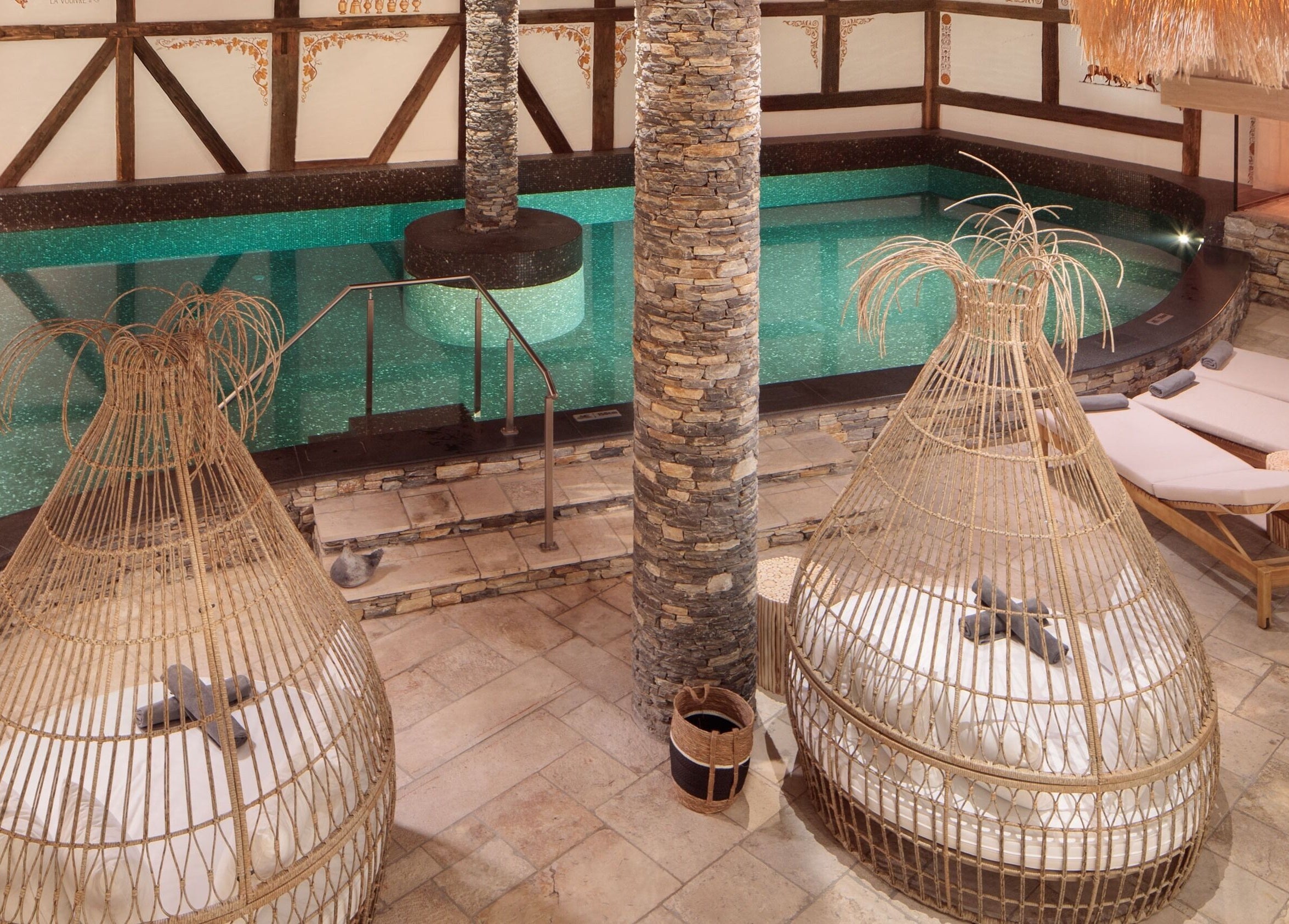 Piscine intérieure luxueuse de L'Aïda Hôtel and Spa à Crans-Montana, Valais, CH, entourée de transats élégants.