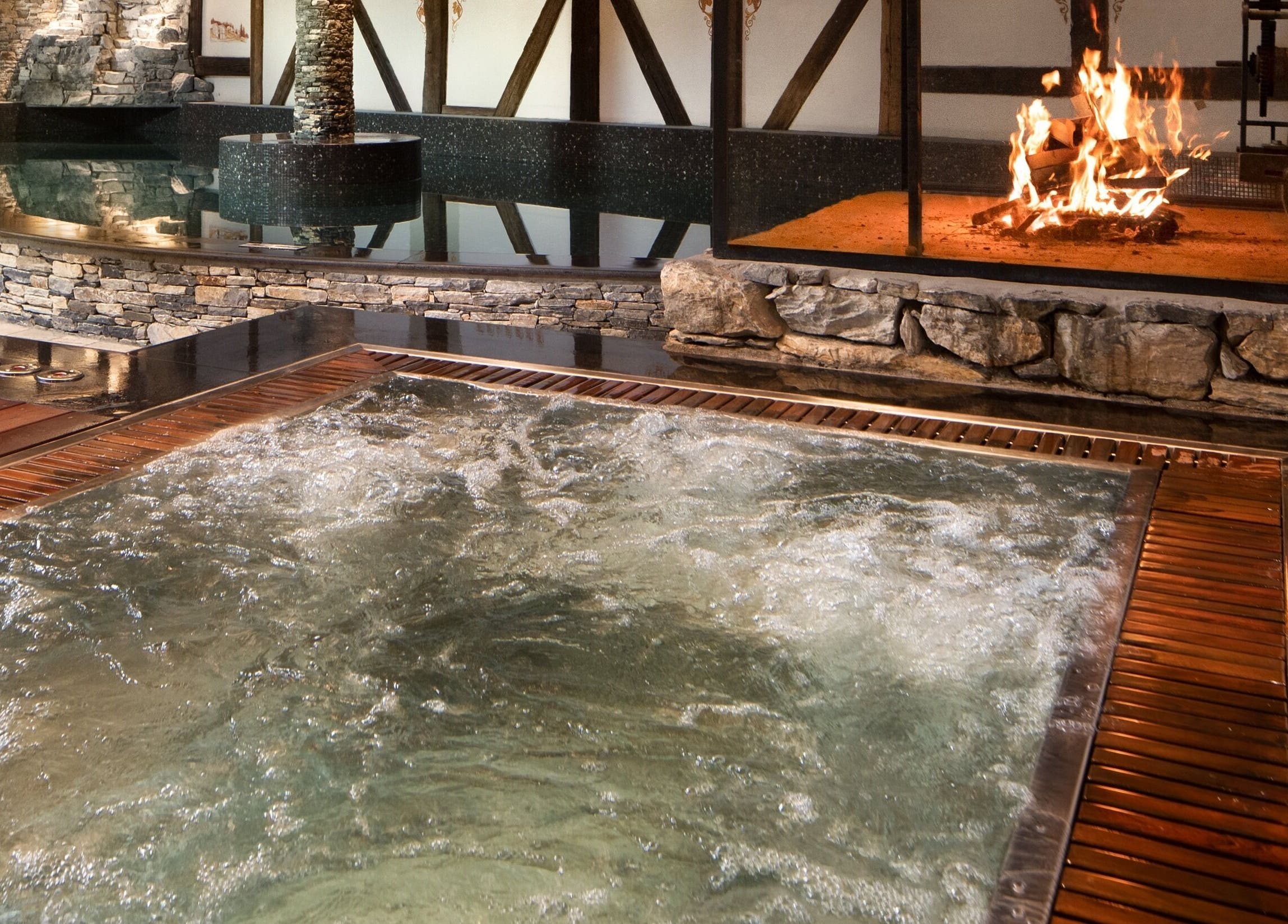 Piscine intérieure luxueuse avec cheminée à L'Aïda Hôtel and Spa, Crans-Montana, Valais, CH.