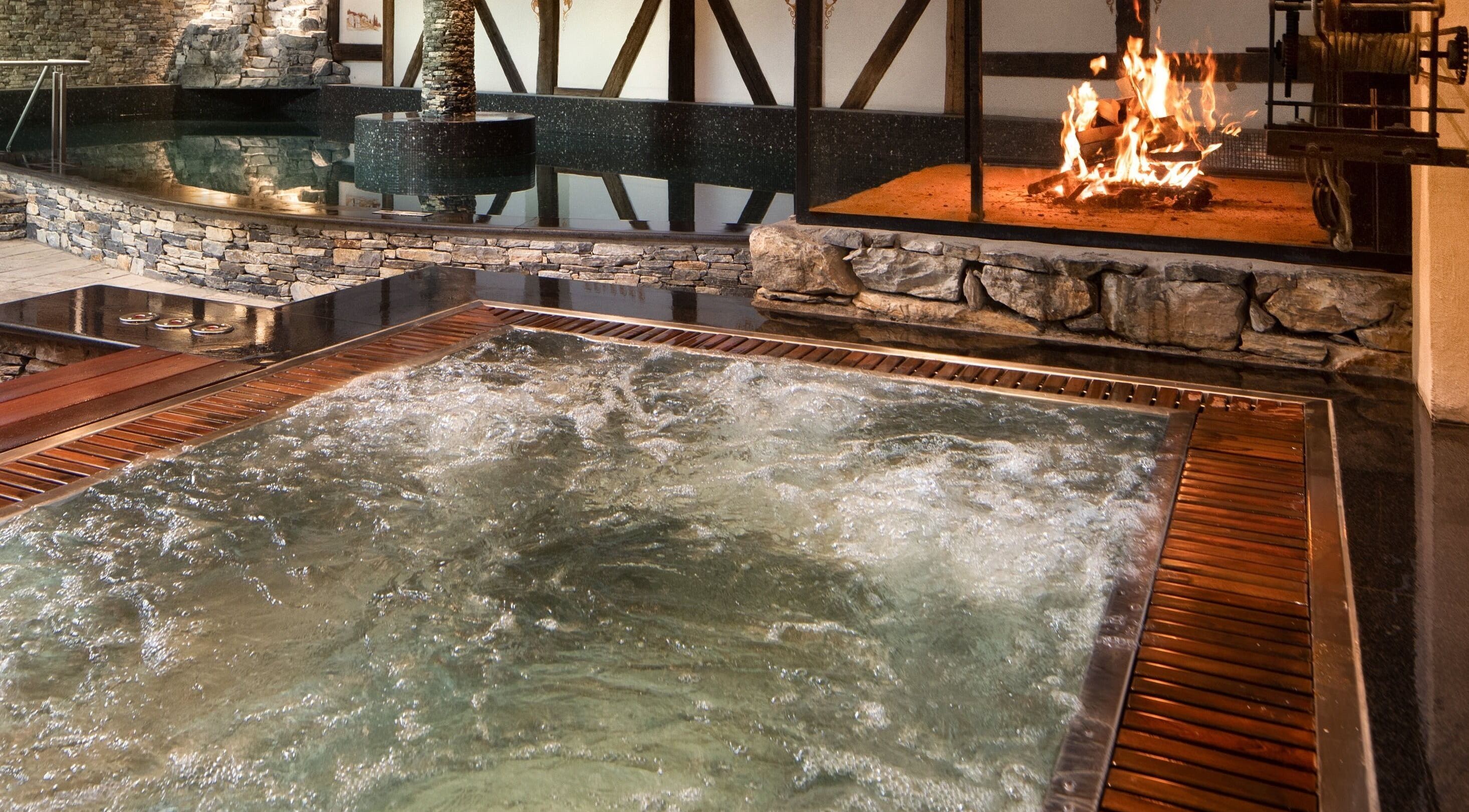 Piscine intérieure luxueuse avec cheminée à L'Aïda Hôtel and Spa, Crans-Montana, Valais, CH.