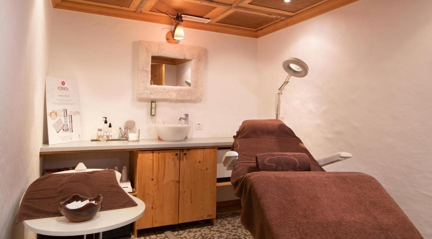Salle de soins élégante à L'Alpage Spa, Crans-Montana, Valais, CH avec ambiance chaleureuse.