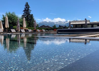 Piscine extérieure à L'Alpage Spa, Crans-Montana, Valais, CH avec vue sur les montagnes enneigées.