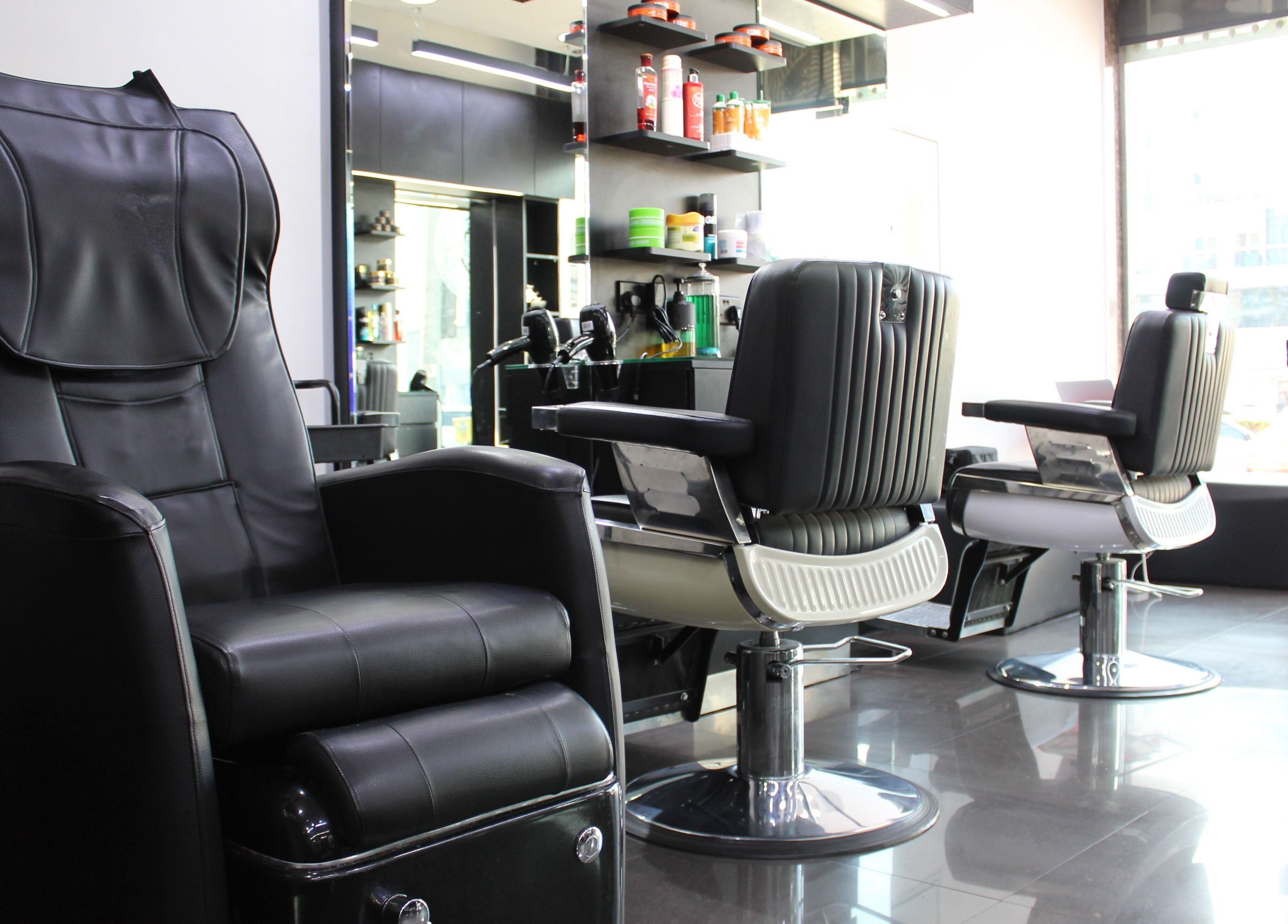 Interior view of Matinee Gents Salon in Dubai, AE, featuring sleek black barber chairs and modern decor.