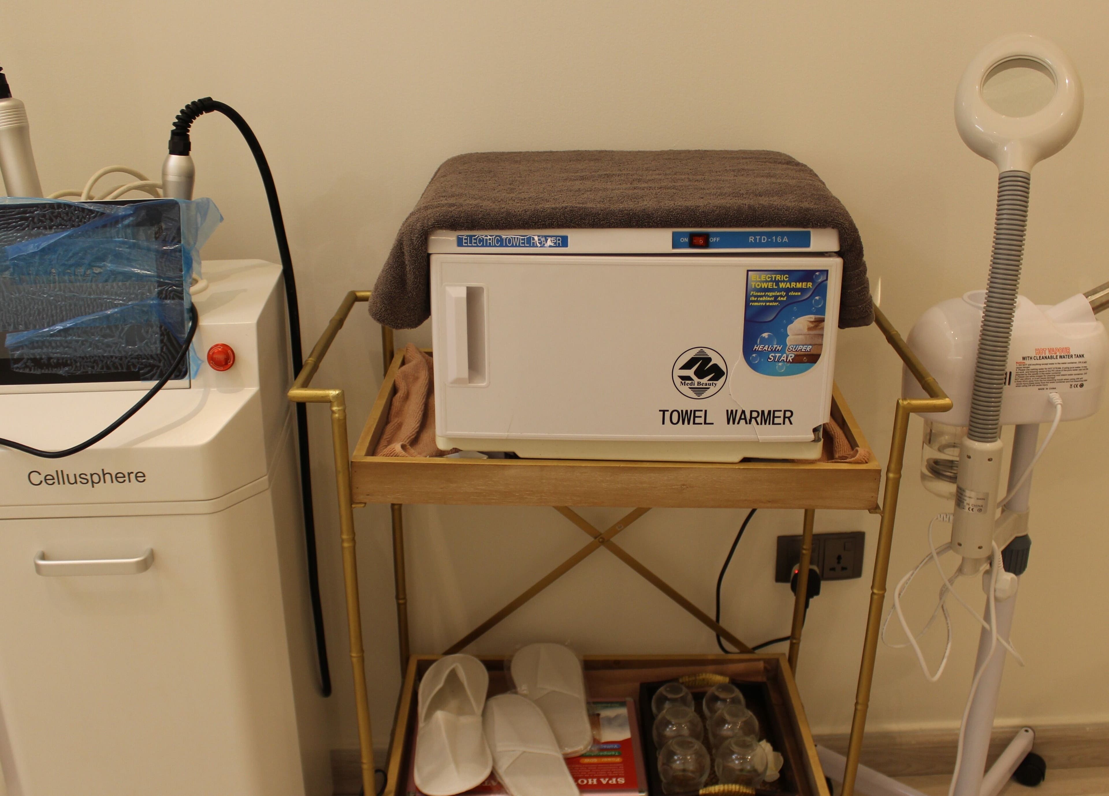 Advanced skincare equipment at Skin Glow Facial Center in Abu Dhabi, AE, featuring high-tech towel warmer and cellusphere.