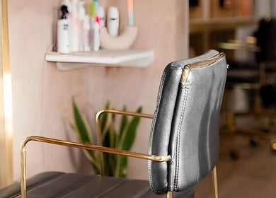Modern salon chair at Carley Bayne Hair, Epsom, England, GB with stylish decor and hair products.