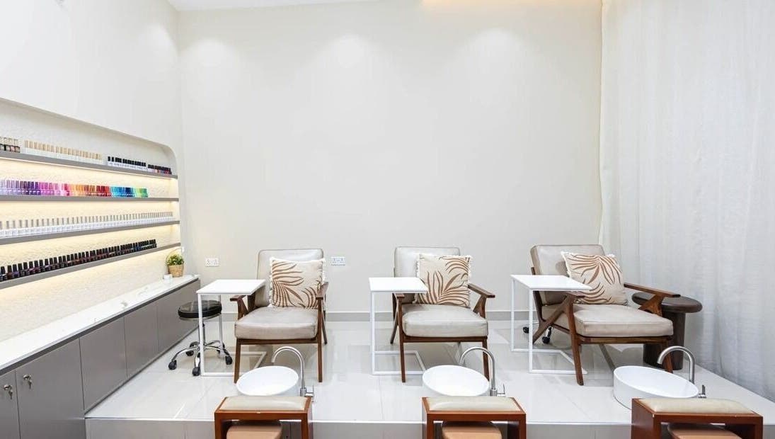 Luxurious pedicure area at Maja Beauty Bar in Dubai, Dubai, AE with comfortable chairs and nail polish displays.
