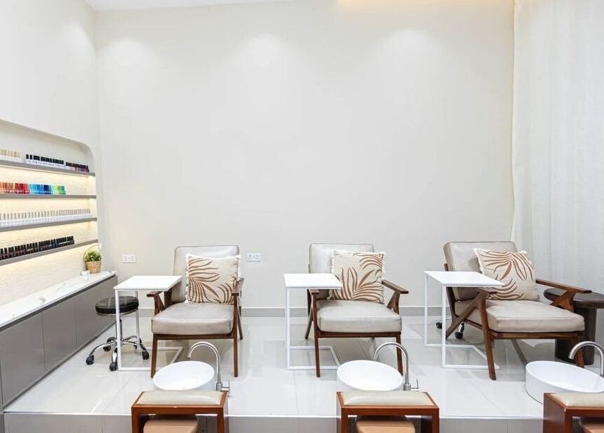 Luxurious pedicure area at Maja Beauty Bar in Dubai, Dubai, AE with comfortable chairs and nail polish displays.