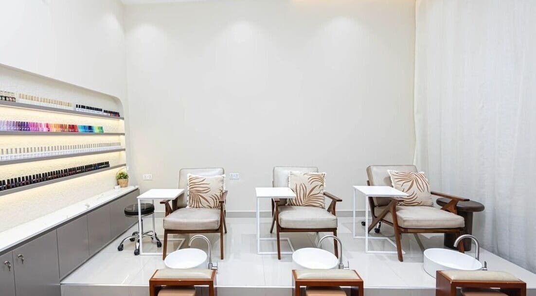 Luxurious pedicure area at Maja Beauty Bar in Dubai, Dubai, AE with comfortable chairs and nail polish displays.