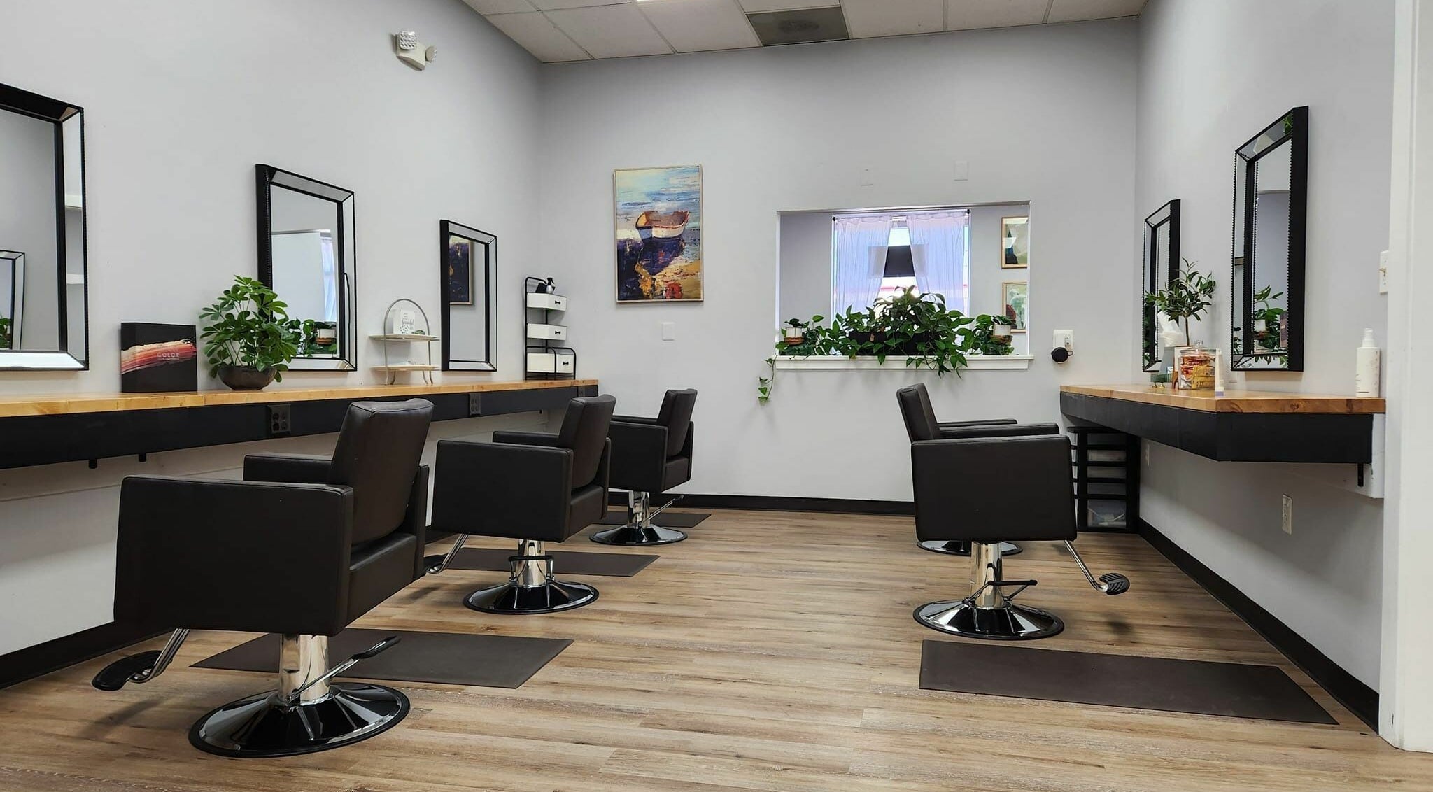 Modern salon chairs and mirrors at The Hair Company, LLC in Sykesville, Maryland, US, featuring stylish decor.