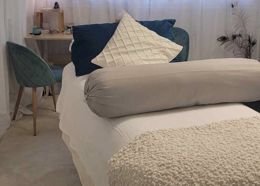 Relaxing treatment room at Metamorphosis Awakening in Tweed Heads, New South Wales, AU, featuring cozy bed and chair.