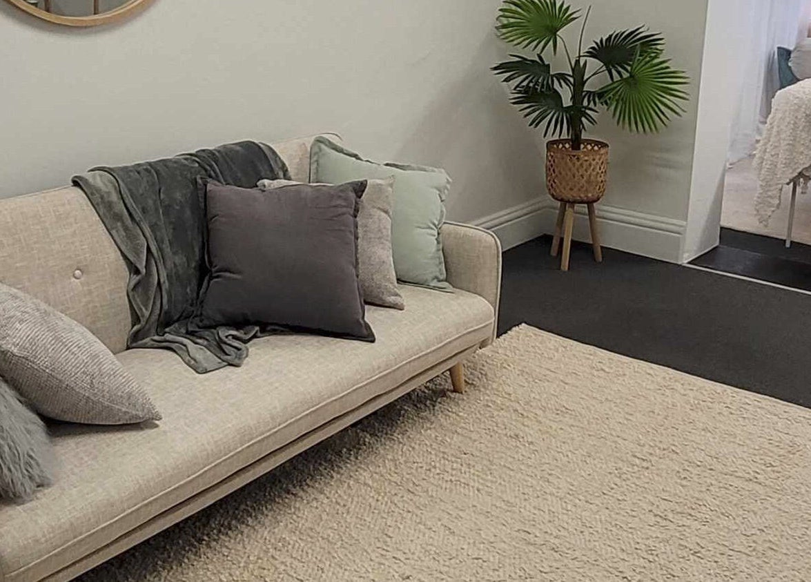 Inviting lounge area at Metamorphosis Awakening, Tweed Heads, New South Wales, AU, featuring a modern sofa and plant.