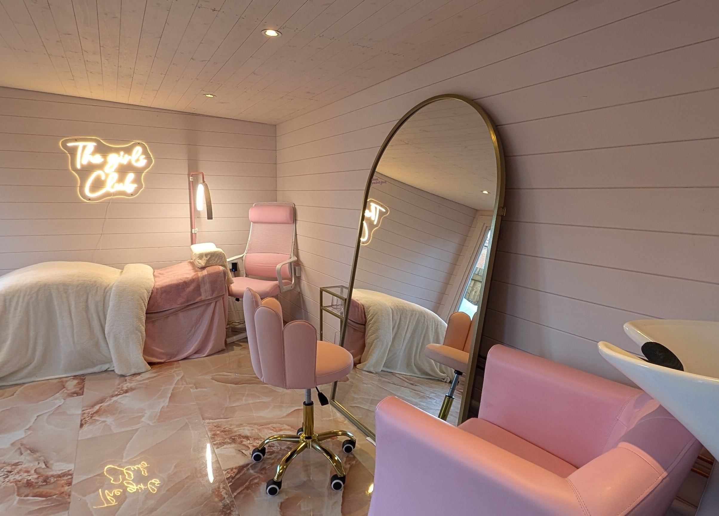 Cozy interior of The Girls Club in Whittselsey, England, GB with pink decor and neon signage.