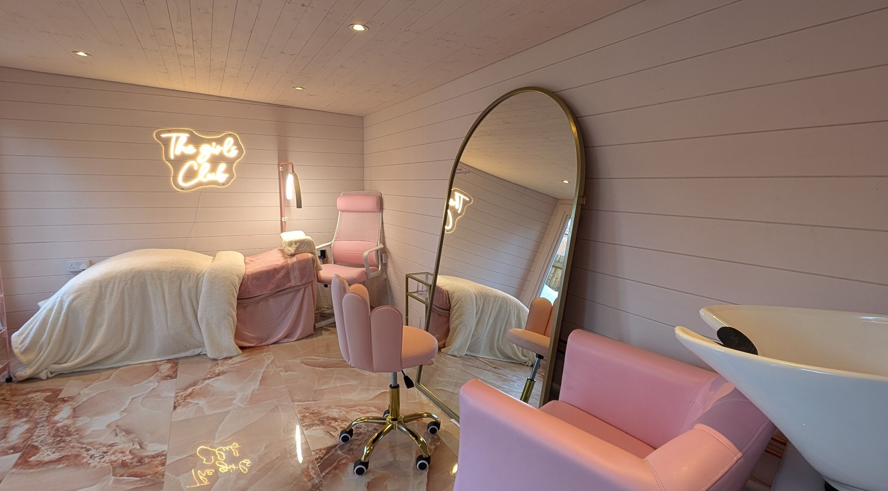 Cozy interior of The Girls Club in Whittselsey, England, GB with pink decor and neon signage.