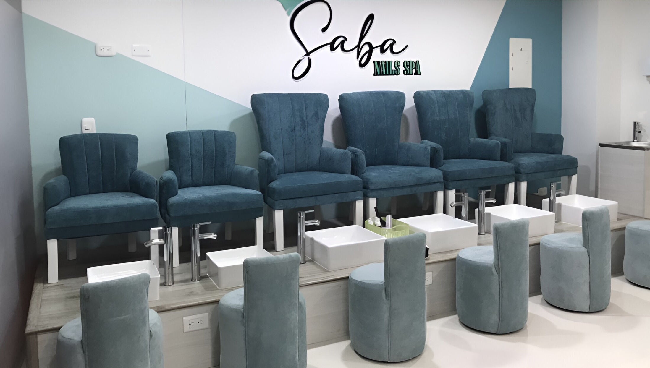 Zona de pedicura en Saba Nails Spa Sede Caney, Fusagasuga, Cundinamarca, CO, con elegantes sillas azules.
