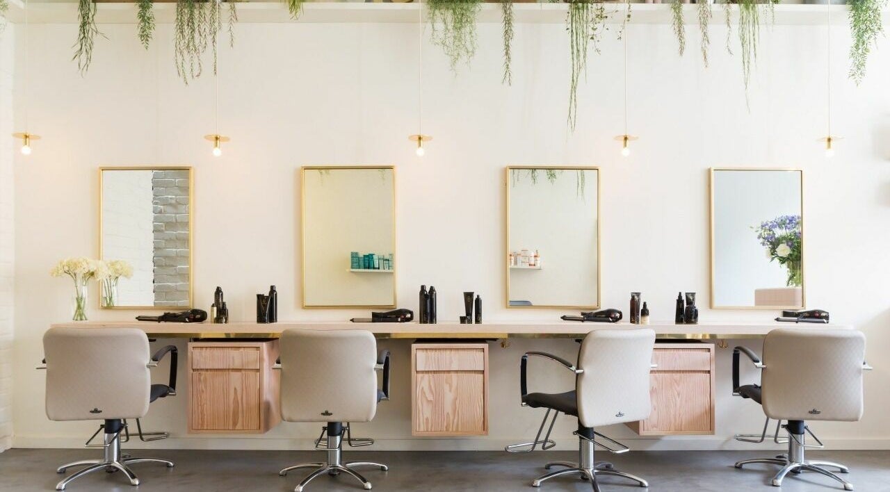Elegant interior of Aer Salon, London, England, GB featuring styling chairs and mirrors for a luxe hair experience.
