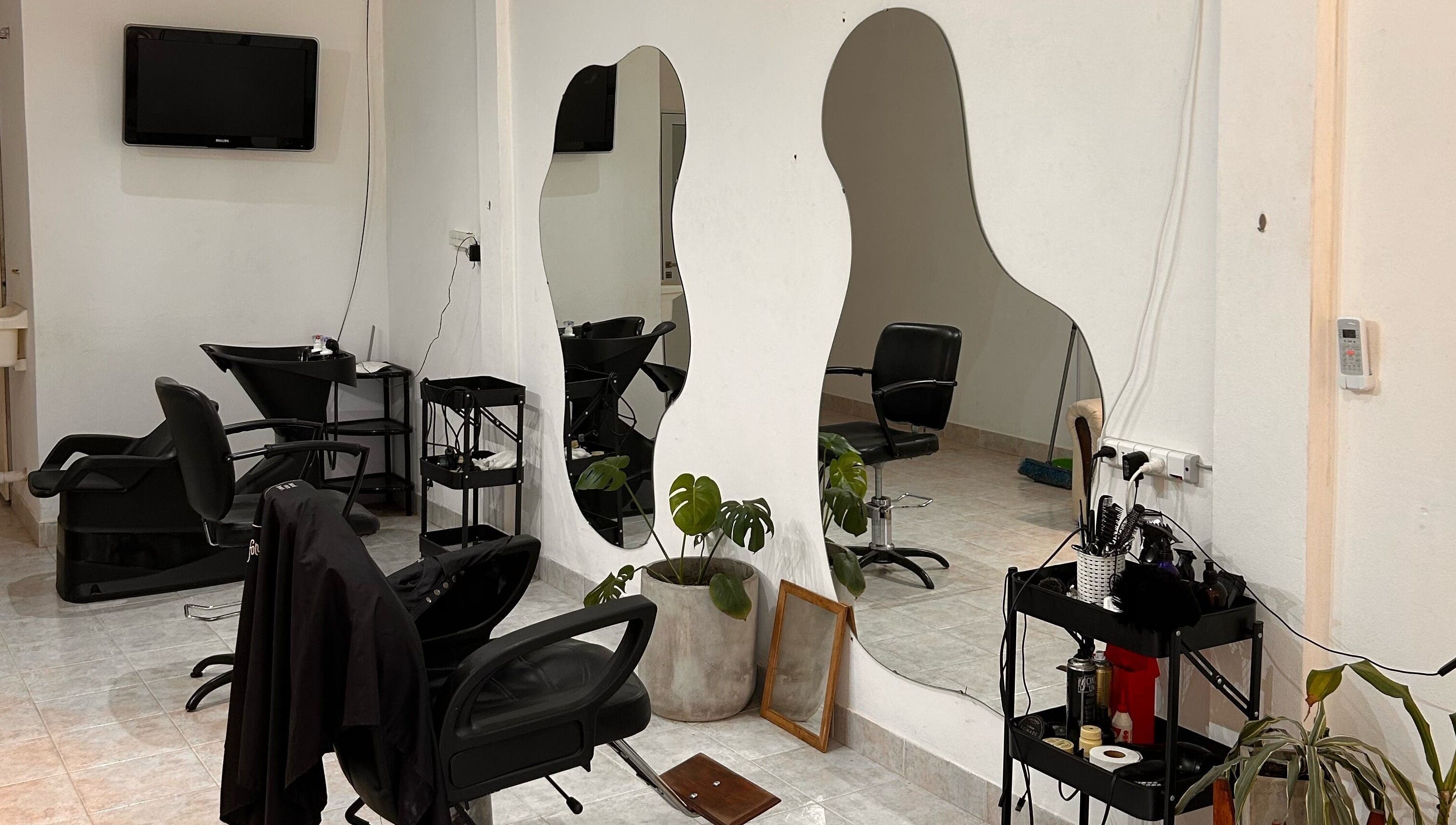 Interior moderno de Classy Cut con espejos curvados y sillas en Paraná, Entre Ríos, AR.