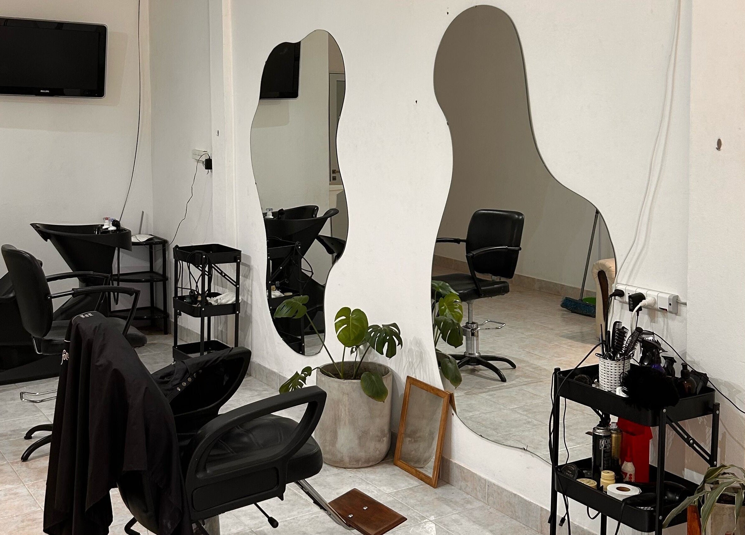 Interior moderno de Classy Cut con espejos curvados y sillas en Paraná, Entre Ríos, AR.