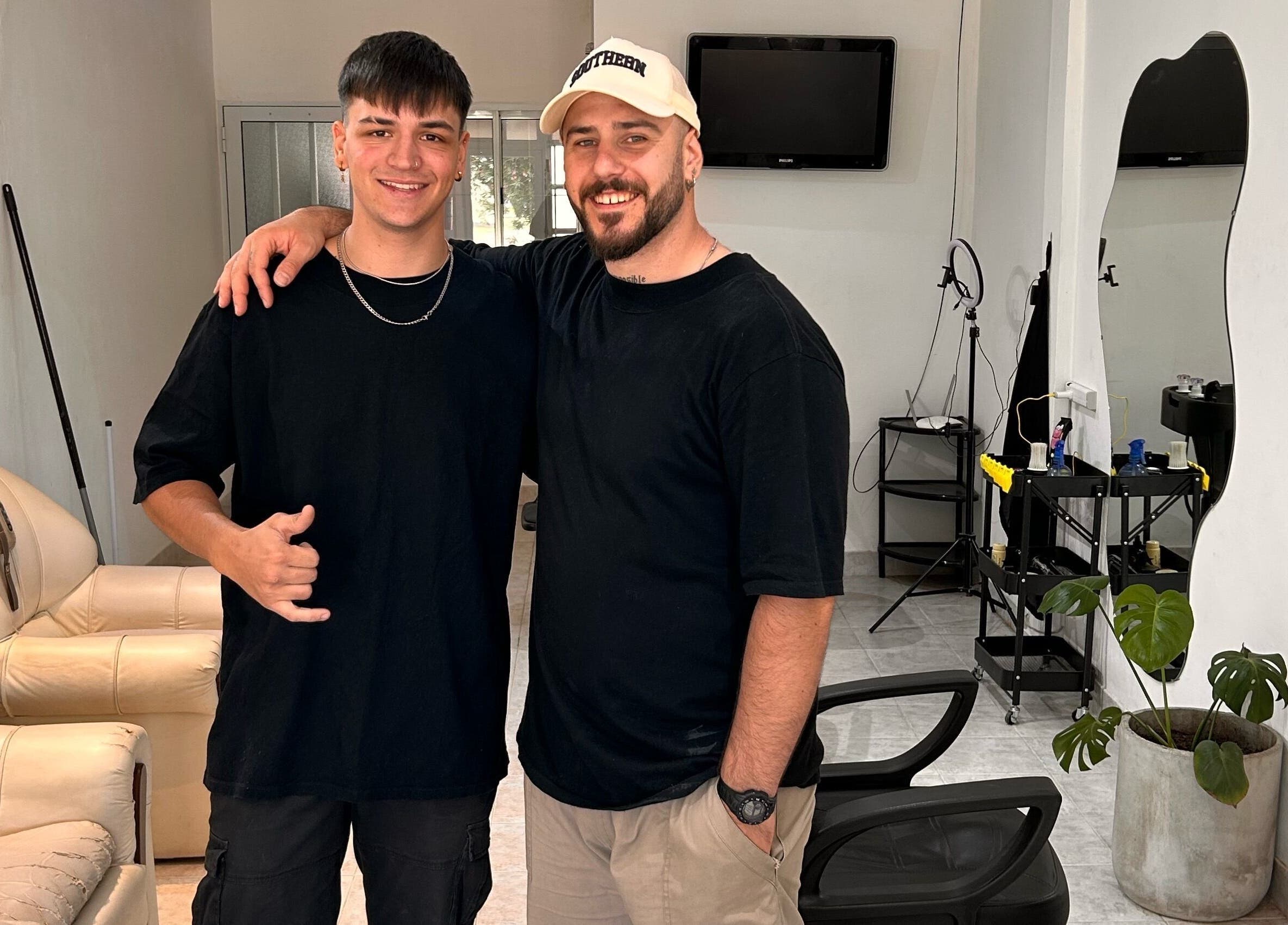 Dos personas sonrientes en el salón Classy Cut en Paraná, Entre Ríos, AR, mostrando felicidad y camaradería.