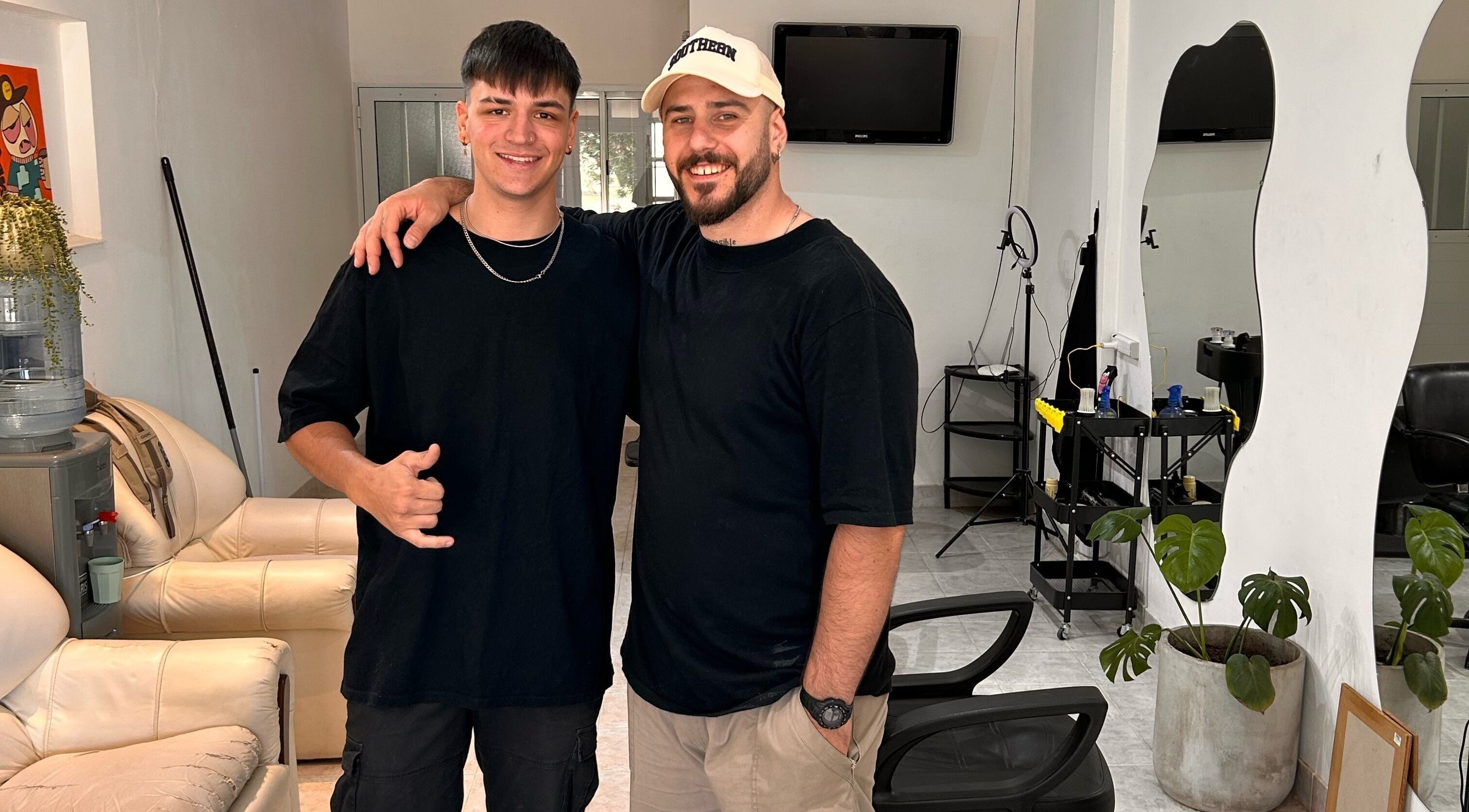 Dos personas sonrientes en el salón Classy Cut en Paraná, Entre Ríos, AR, mostrando felicidad y camaradería.