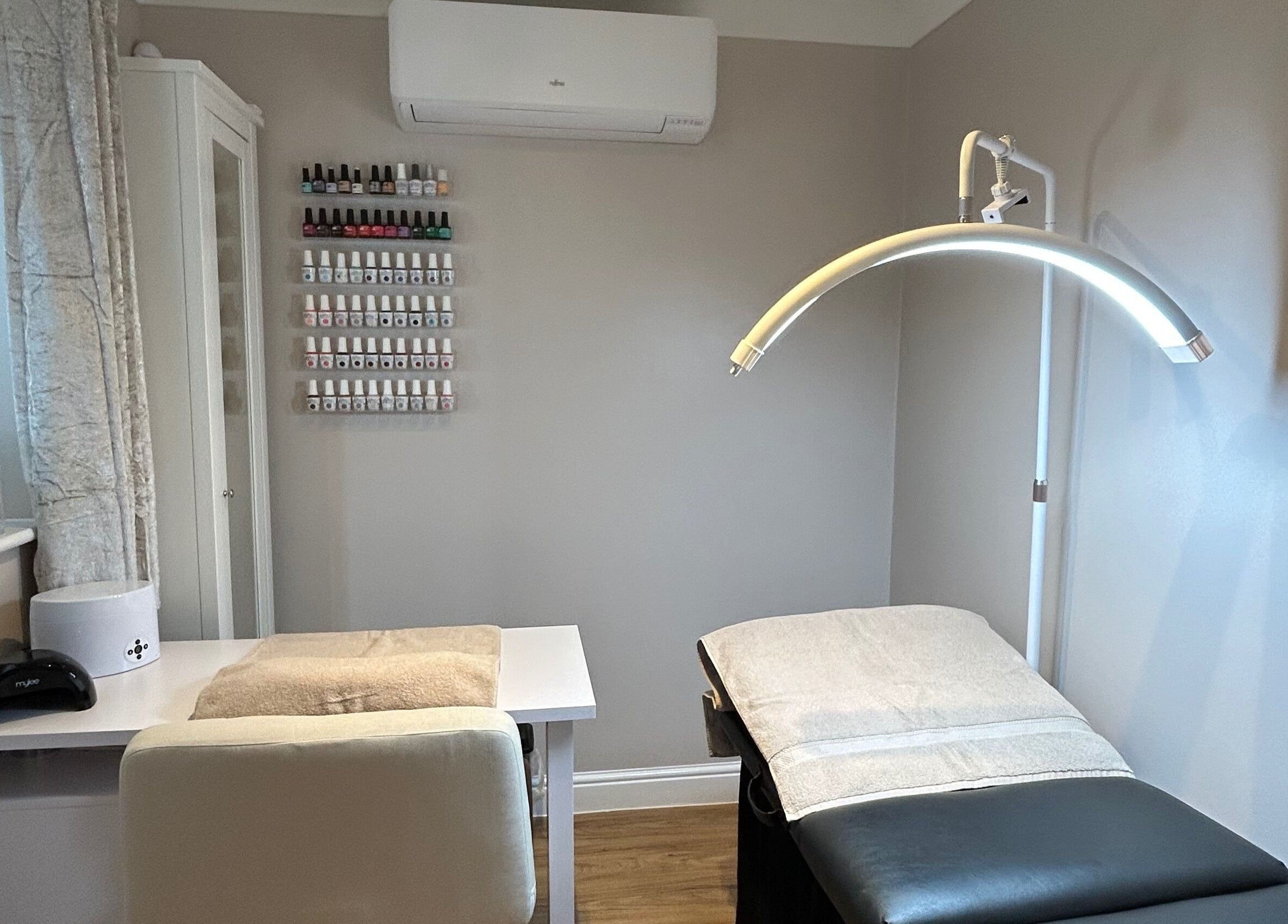Tranquil treatment room at Beauty Box by Becky McDaid, Peterborough, England, GB with cozy spa bed and nail polishes.