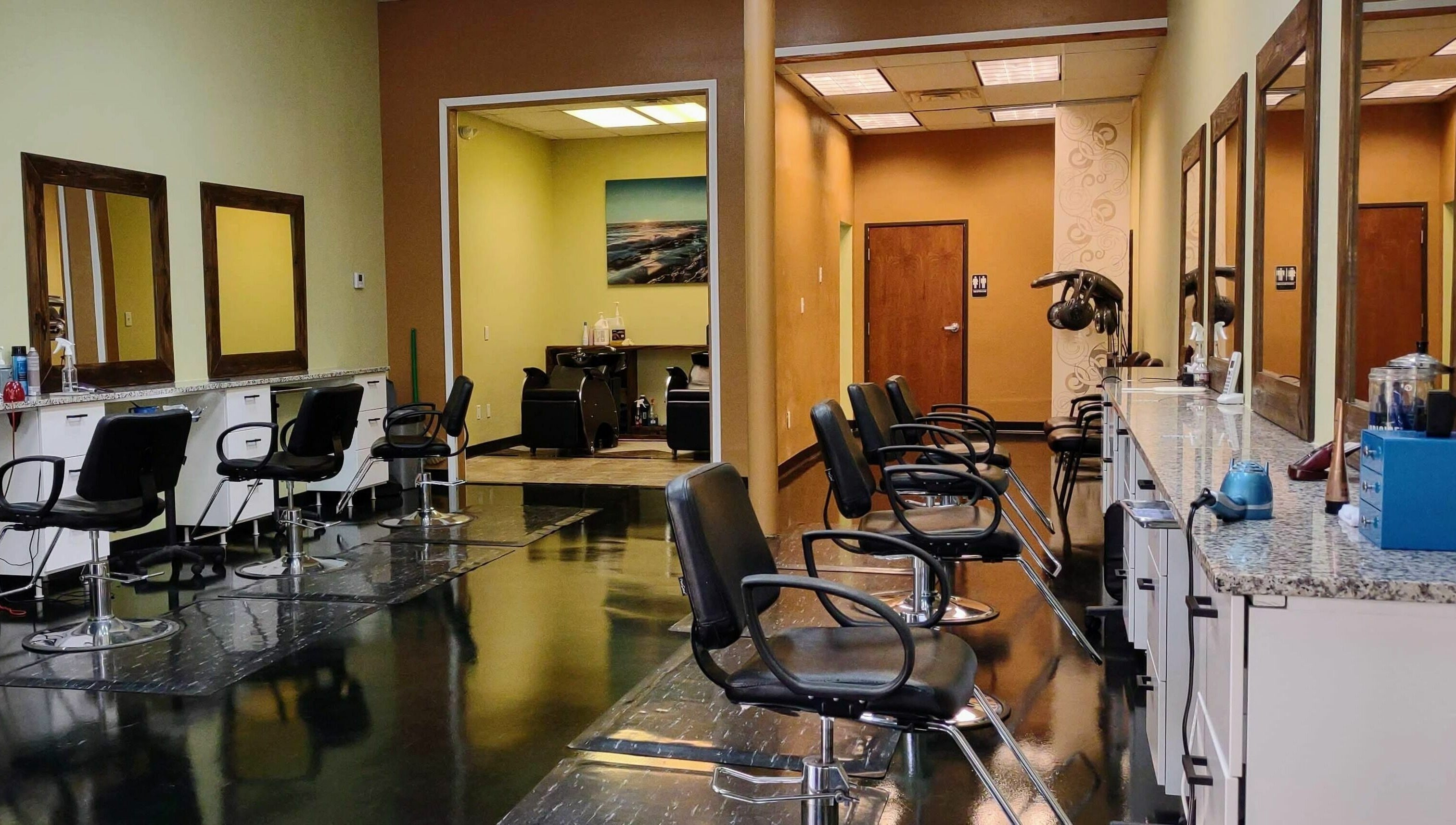 Interior of Creative Cuts in Austin, Texas, US. Modern salon chairs and mirrors lining the wall.