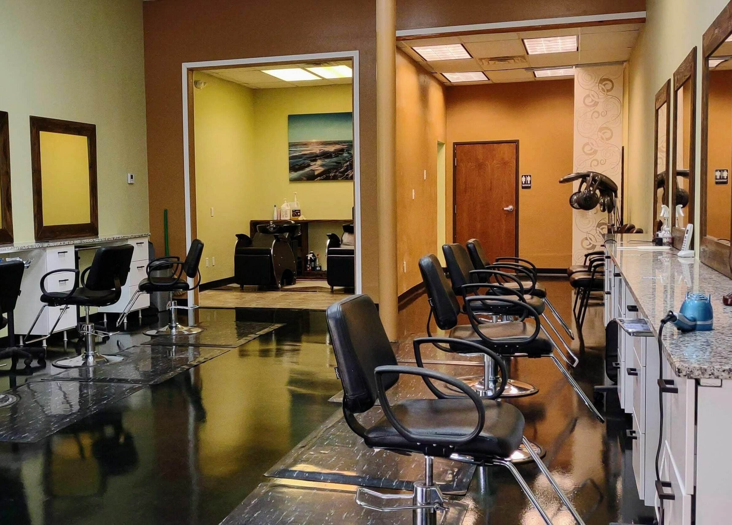 Interior of Creative Cuts in Austin, Texas, US. Modern salon chairs and mirrors lining the wall.