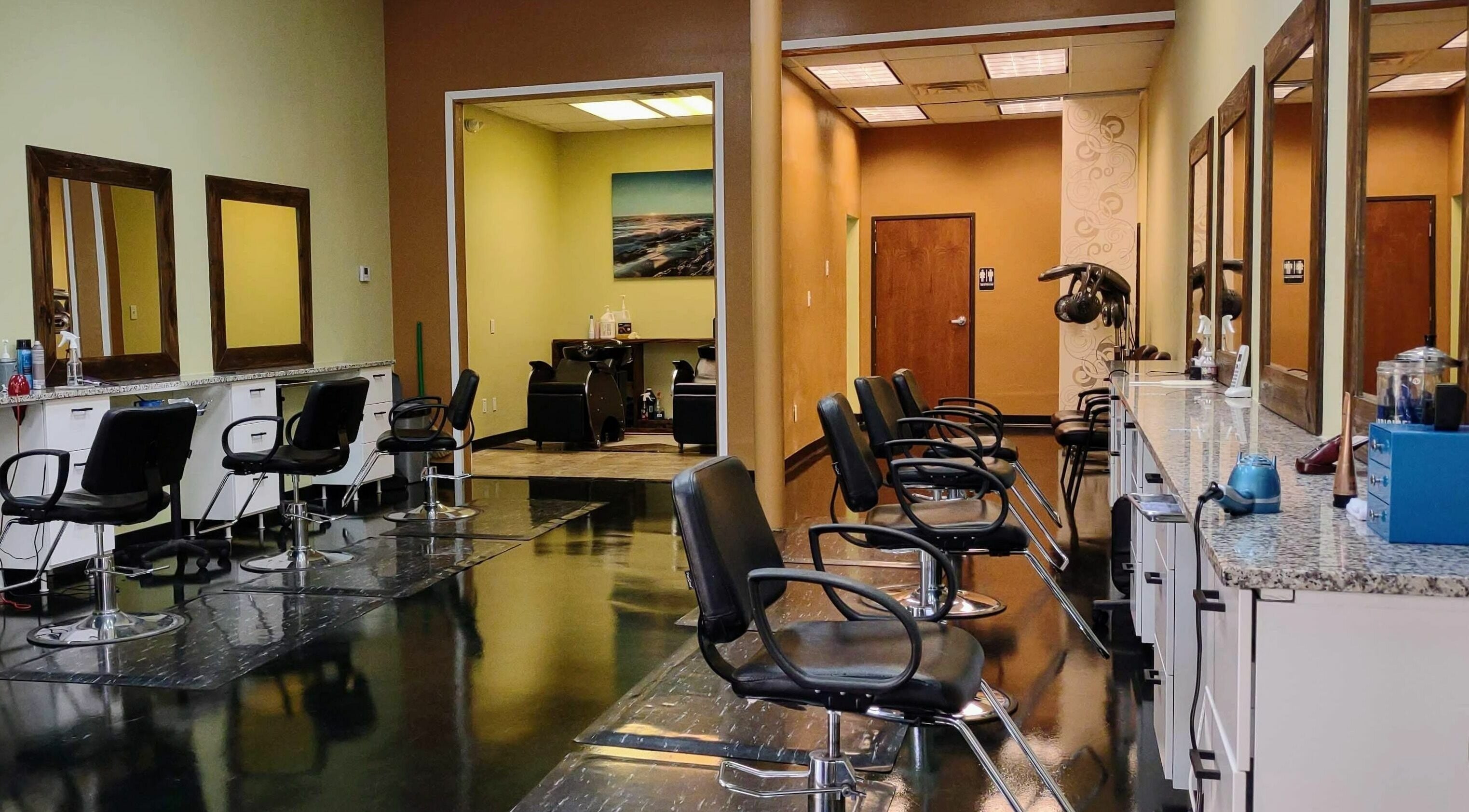 Interior of Creative Cuts in Austin, Texas, US. Modern salon chairs and mirrors lining the wall.