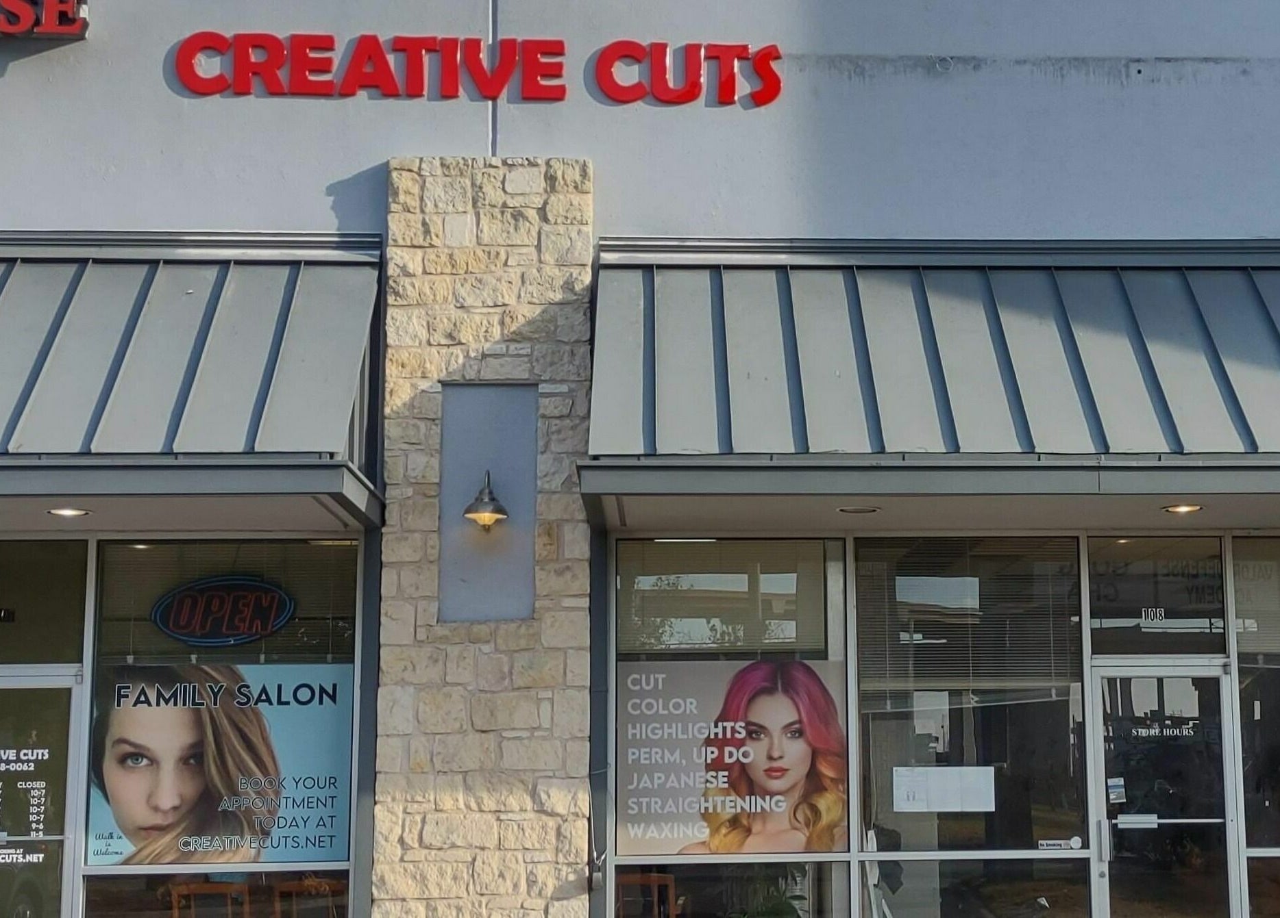 Exterior view of Creative Cuts salon in Austin, Texas, US with bold signage.