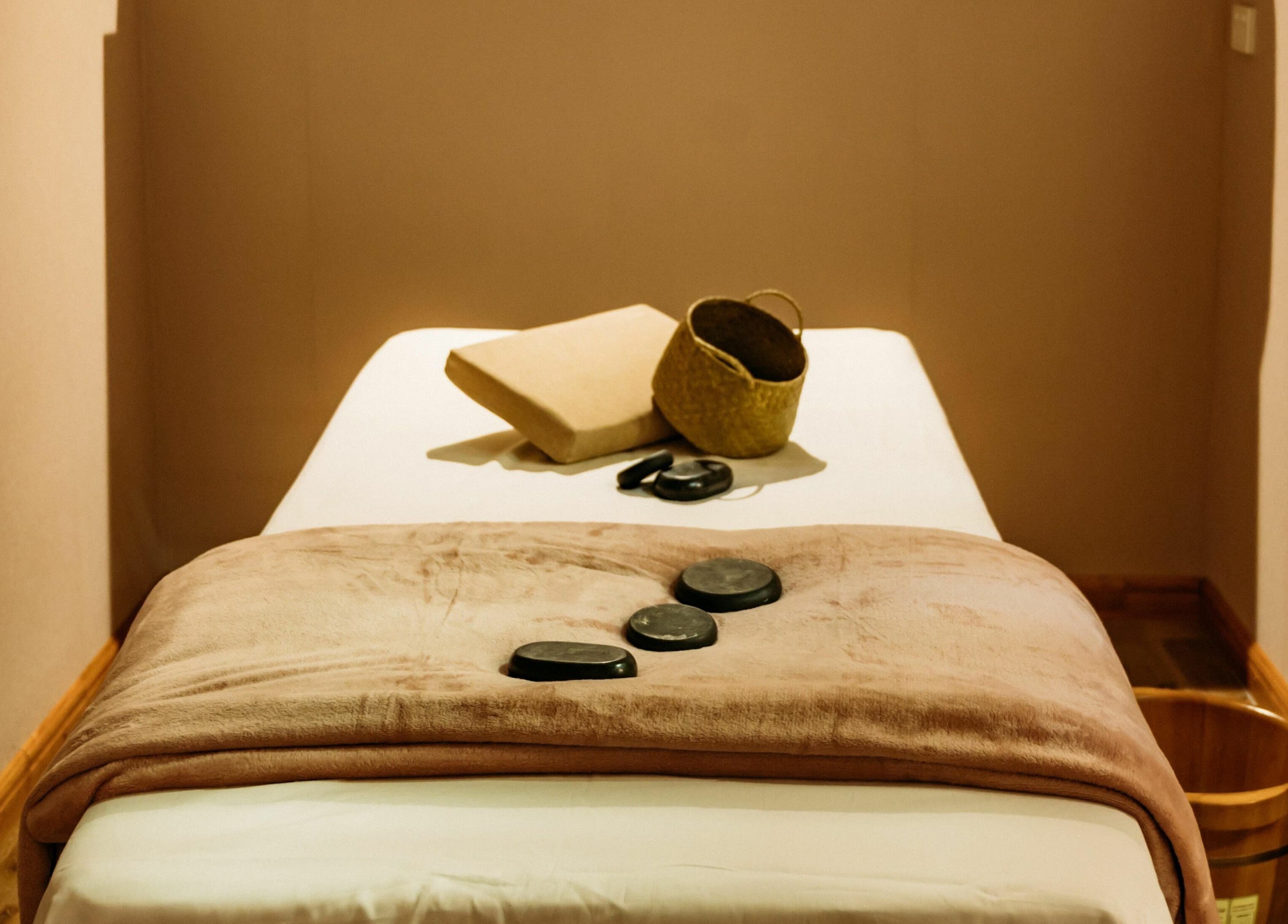 Cozy massage room at Lu’s Massage, Joondalup, Western Australia, AU, with hot stones on a plush towel.