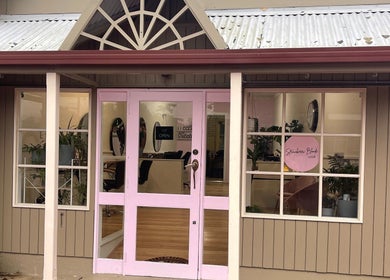 Exterior of Strawberri Blonde in Geeveston, Tasmania, AU, showcasing a welcoming entrance with pink accents.