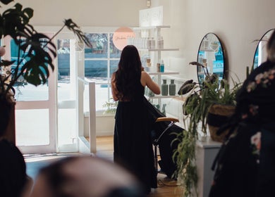 Interior of Strawberri Blonde in Geeveston, Tasmania, AU, showcasing a stylist working amid chic decor.