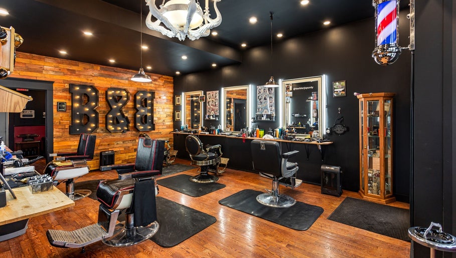 Blades & Bourbon barber shop interior in Gatineau, Québec, CA featuring stylish chairs and rustic decor.