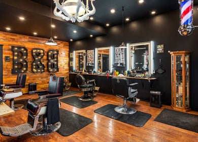 Blades & Bourbon barber shop interior in Gatineau, Québec, CA featuring stylish chairs and rustic decor.