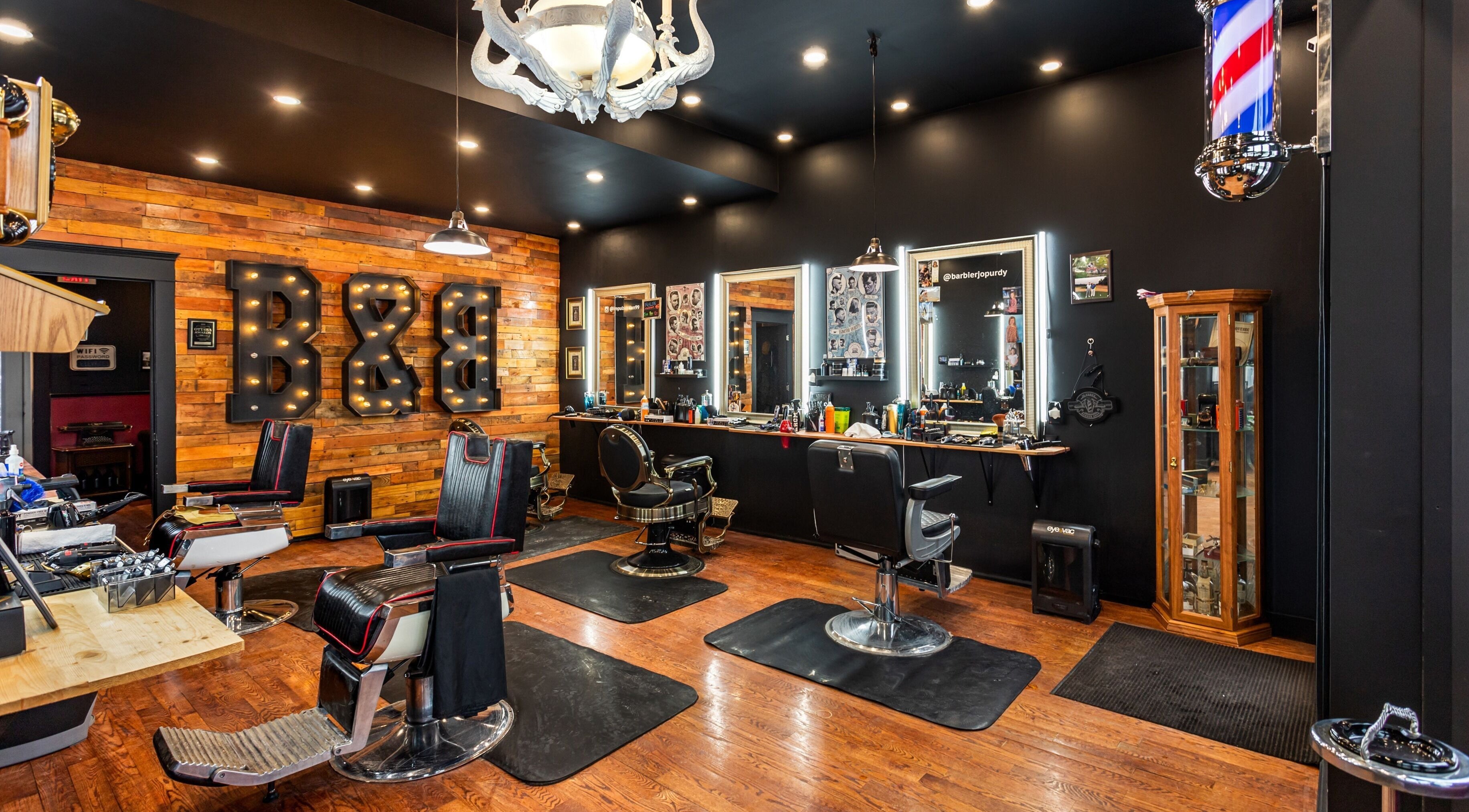 Blades & Bourbon barber shop interior in Gatineau, Québec, CA featuring stylish chairs and rustic decor.