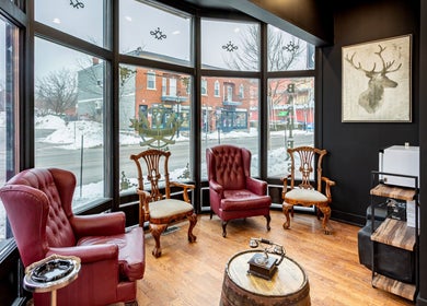 Elegant seating area at Blades & Bourbon, Gatineau, Québec, CA with vintage decor and large windows.
