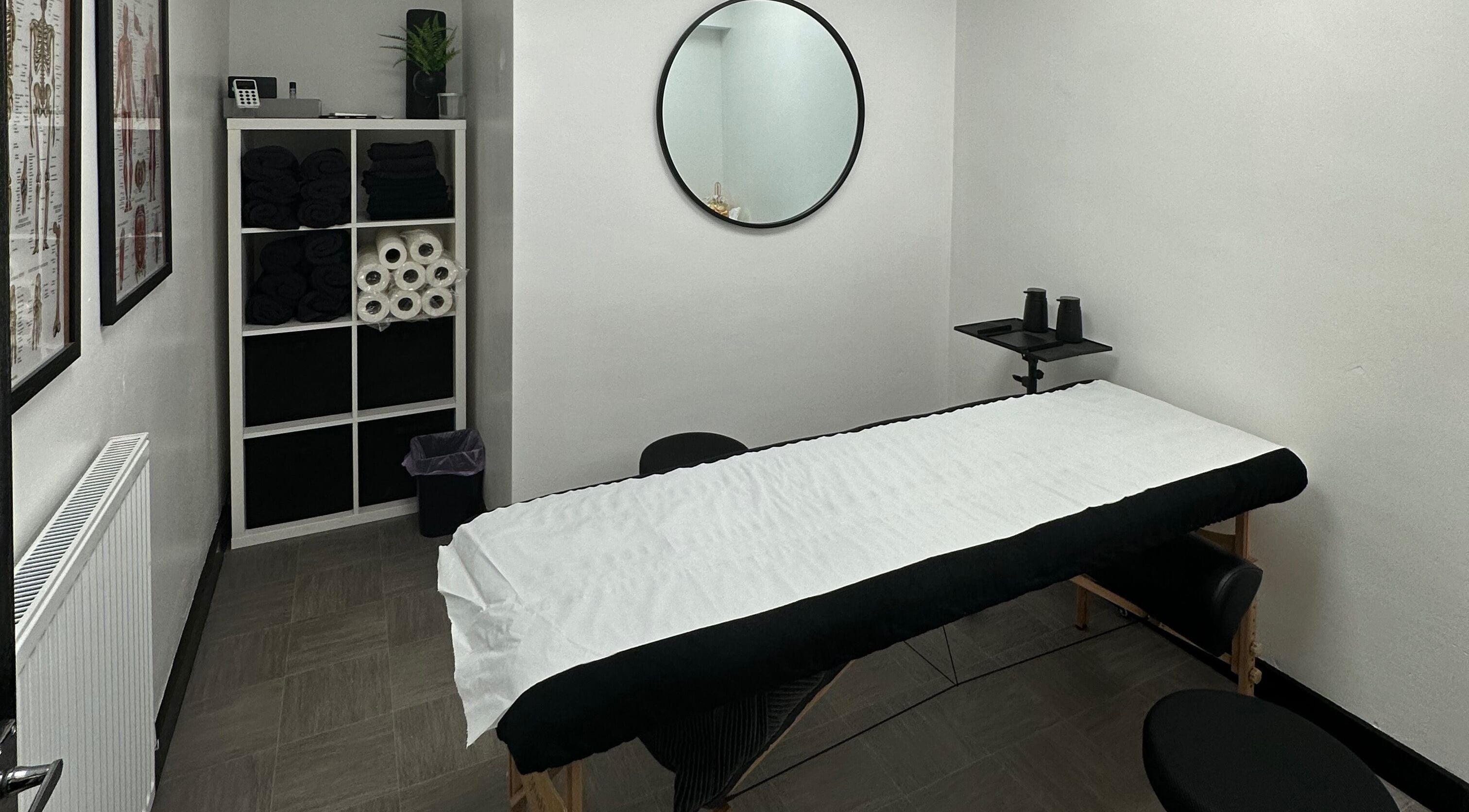 Opal Sports Therapy cozy massage room in Cheadle, England, GB with a therapy bed and neatly stacked towels.