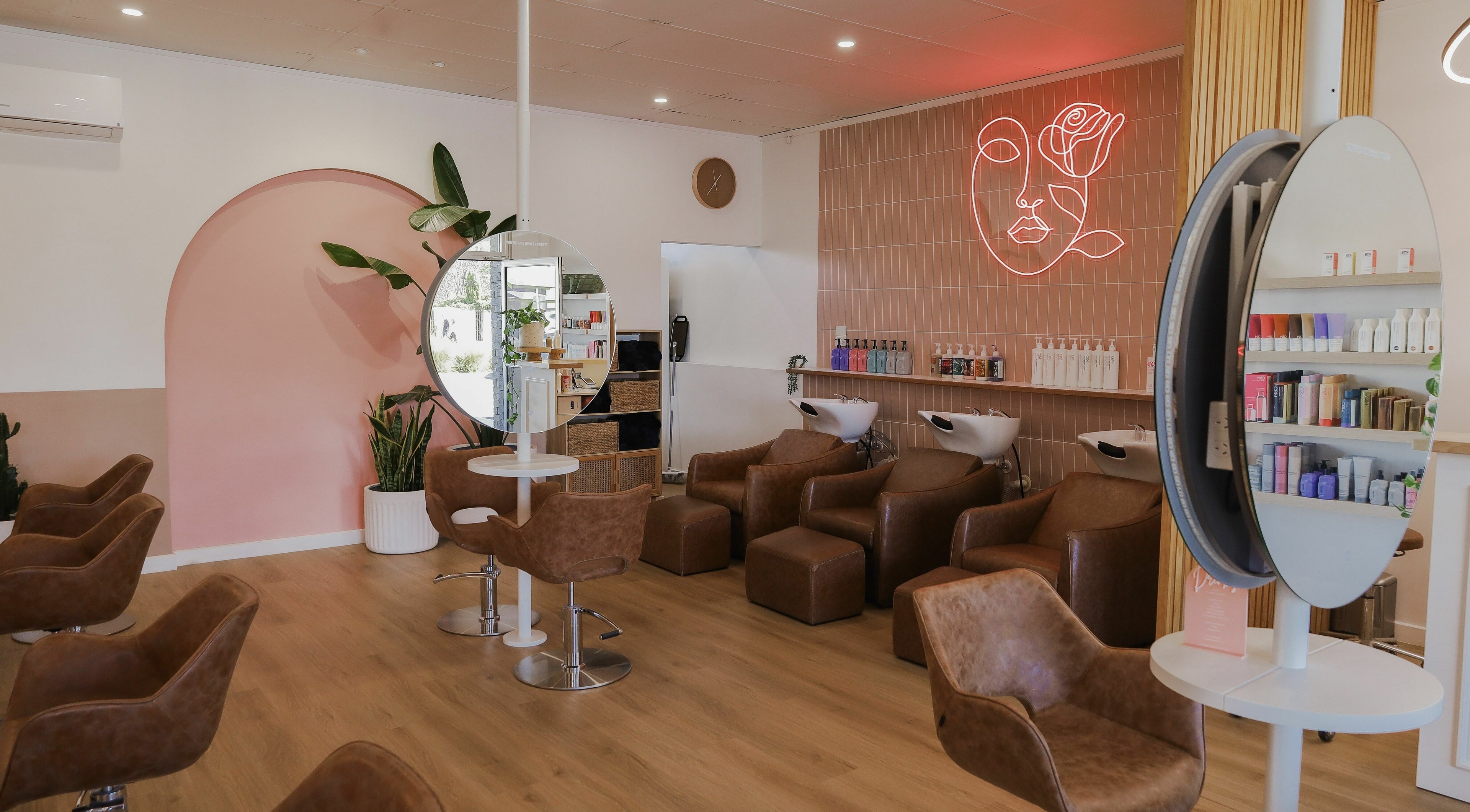 Bright interior of Dirty Blonde Hair Studio in Hove, South Australia, AU with stylish brown chairs and decor.